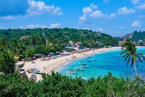 a beach in the philippines with boats in the water at Galle Fantacy in Unawatuna