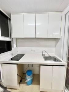 een keuken met witte kasten en een wastafel bij Zenmist Properties- 2 Bedroom Deluxe in Baguio