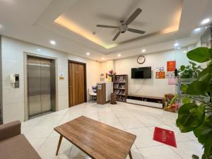 a living room with a ceiling fan and a table at NINE HOUSING Buoi Street in Hanoi