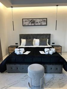 a bedroom with a large black bed with a stool at DIADEMA Luxury Suite in Nardò