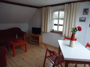 a living room with a table with a vase of flowers on it at Zur alten Jugendherberge in Burg
