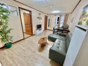 een woonkamer met een bank en een tafel bij Zenmist Properties- 2 Bedroom Deluxe in Baguio