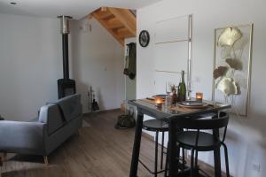 ein Wohnzimmer mit einem Tisch, Stühlen und einem Sofa in der Unterkunft Happy & Relax in Mentque-Nortbécourt