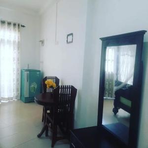 a dining room with a table and a mirror at Galle Fantacy in Unawatuna