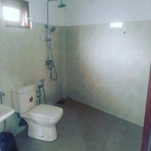 a bathroom with a white toilet and a sink at Galle Fantacy in Unawatuna