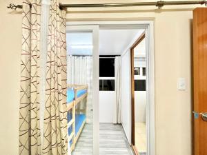 uma porta de vidro deslizante que dá acesso a um quarto com uma varanda em Zenmist Properties- 2 Bedroom Deluxe em Baguio