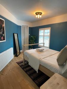 um quarto com uma cama grande e paredes azuis em Hoole House- Bright and modern 2 bedroom house, close to Chester train station and the City Centre em Chester