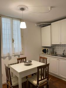 a kitchen with a white table and chairs and a sink at Ca' Frezzeria in Venice