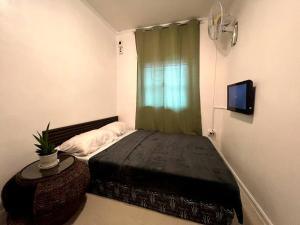 - une petite chambre avec un lit et une télévision dans l'établissement Affordable 3 Bedroom Lodge (Free Wi-Fi + Netflix), à Ángeles