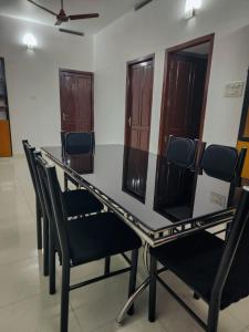 a glass dining table and chairs in a room at Urban Haven Short Stays in Trivandrum