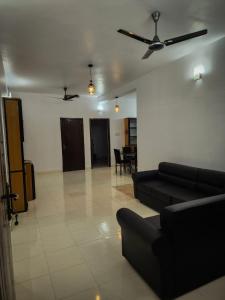 a living room with a couch and a ceiling fan at Urban Haven Short Stays in Trivandrum
