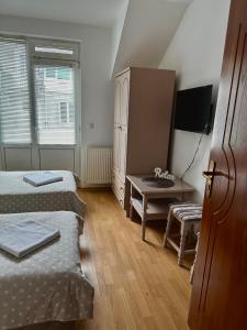 a small bedroom with two beds and a tv at Apartment VEDA 2 in Veliko Tŭrnovo