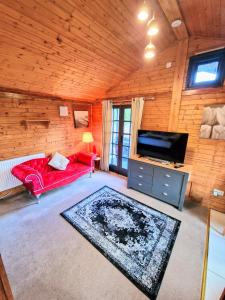 ein Wohnzimmer mit einem roten Sofa und einem Flachbild-TV in der Unterkunft Otter 4 Hot Tub - HuntersMoon-Warminster-Bath-Salisbury in Warminster