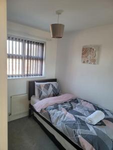 a bedroom with a bed and a window at 2 Bedroom end of terrace house in Wellington