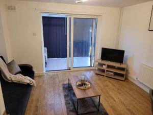 a living room with a couch and a tv and a table at 2 Bedroom end of terrace house in Wellington