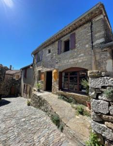a large stone building with a stone walkway in front of it at appartement chez l'artiste in Minerve