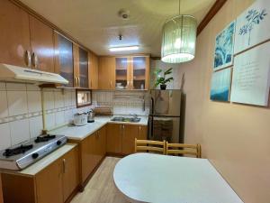 - une cuisine avec des placards en bois et une table dans l'établissement Zenmist Properties- 2 Bedroom Economy, à Baguio