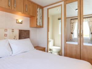 een slaapkamer met een wit bed en een toilet bij Whiteside in Cockermouth