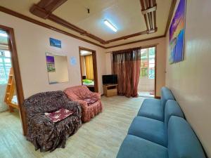 a living room with a blue couch and a chair at Zenmist Properties- 2 Bedroom Economy in Baguio