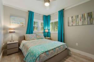 1 dormitorio con 1 cama con cortinas azules en Shady Oaks Beach House With Beautiful Ocean Views!, en Gulfport