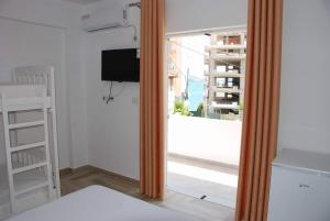 Habitación con puerta corredera de cristal y ventana en The Hill Apartment, en Sarandë