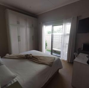 a bedroom with a bed and a large window at Emerald Boutique Guesthouse in Queenstown