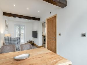 a kitchen and dining room with a wooden table at Barn One in Sandbach