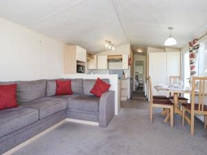 a living room with a couch and a table and a kitchen at Swinside in Cockermouth