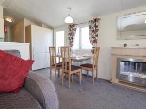 a living room with a table and chairs and a fireplace at Swinside in Cockermouth