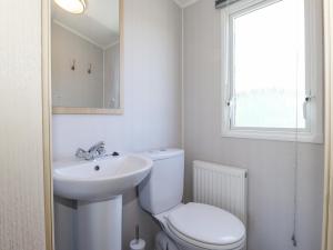 a bathroom with a toilet and a sink and a window at Swinside in Cockermouth +20 photos