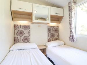 two beds in a small room with a window at Swinside in Cockermouth