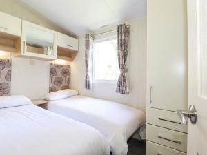 two beds in a small room with a window at Swinside in Cockermouth