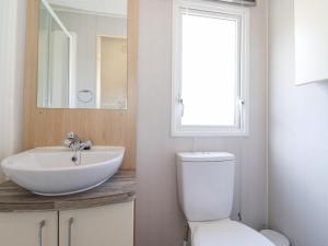 a bathroom with a sink and a toilet and a mirror at Swinside in Cockermouth