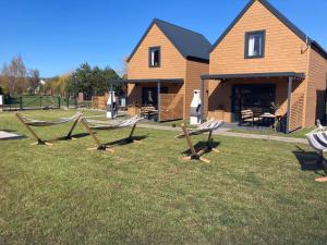 a group of benches in the grass in front of a house at Domki Kalimera Rewal in Rewal