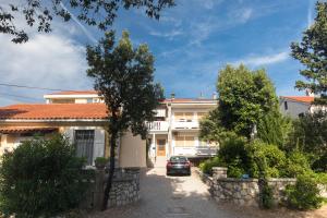 a house with a car parked in front of it at Apartments Mirjana * central location and close to beach in Punat