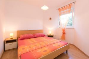 a bedroom with a bed and a window with two lamps at Apartments Mirjana * central location and close to beach in Punat