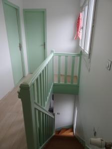 Una escalera verde en una habitación con ventana en Maison d'hôtes les roses trémières, en Saclay