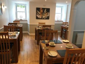 una sala da pranzo con tavoli e sedie in legno di Meadhon Guest House a Jedburgh