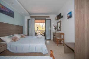 a bedroom with a large white bed and a table at Zefiros by sea in Laganas