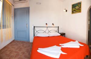 a bed room with a white bedspread and a blue wall at Villa Murano in Fira
