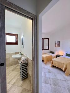 a room with two beds and a bathroom at Appartamento La Conchiglia a pochi passi dal centro in San Teodoro