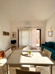 a living room with a table and a blue couch at Appartamento La Conchiglia a pochi passi dal centro in San Teodoro