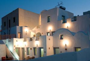a white building with lights on it at night at Villa Murano in Fira