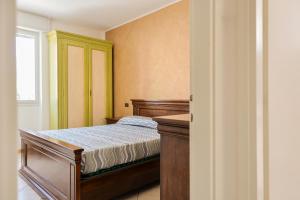 1 dormitorio con cama de madera y ventana en 7 posti nel cuore dell'area pedonale con parcheggio, en Bibione