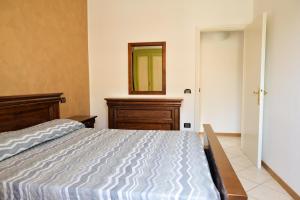 1 dormitorio con 1 cama grande y espejo en 7 posti nel cuore dell'area pedonale con parcheggio, en Bibione