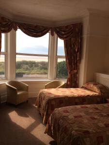 リザム・セント・アンズにあるMonterey Beach Hotelのベッドルーム1室(ベッド2台、大きな窓付)