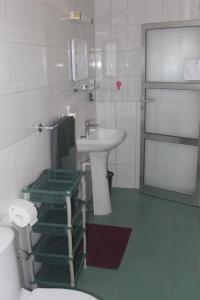 ein Badezimmer mit einem weißen Waschbecken und einem WC in der Unterkunft Le Margouillat 