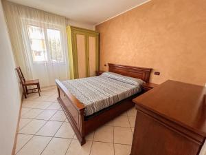 een slaapkamer met een bed, een tafel en een raam bij 7 posti nel cuore dell'area pedonale con parcheggio in Bibione