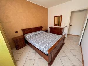 a bedroom with a bed and two dressers and a mirror at 7 posti nel cuore dell'area pedonale con parcheggio in Bibione