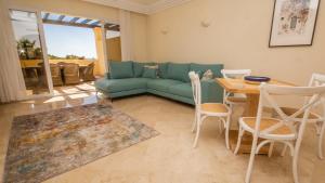 ein Wohnzimmer mit einem grünen Sofa und einem Tisch in der Unterkunft Majestic Hills 1 5 in Casares